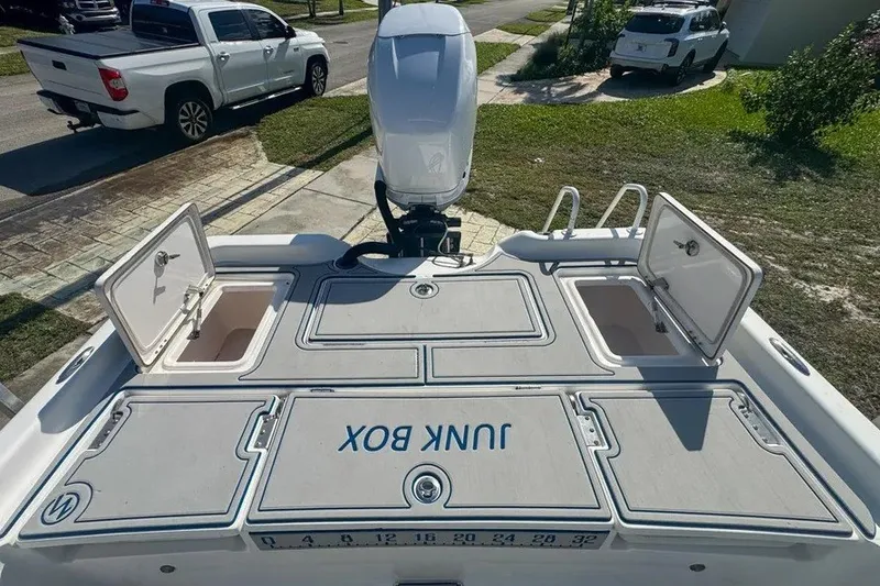 Slide: The Image of 2018 Blue Wave 2400 PureBay boat with open storage compartments and outboard motor. - 53