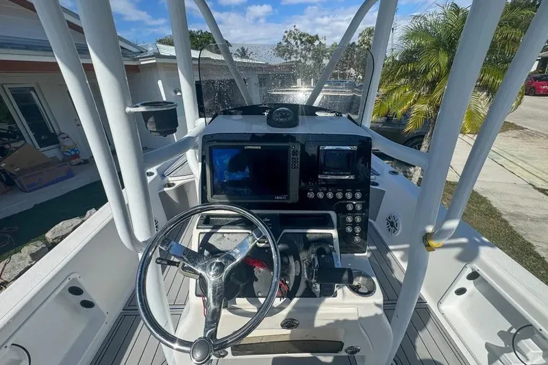 Slide: The Image of 2018 Blue Wave 2400 PureBay boat dashboard with steering wheel and navigation equipment. - 21