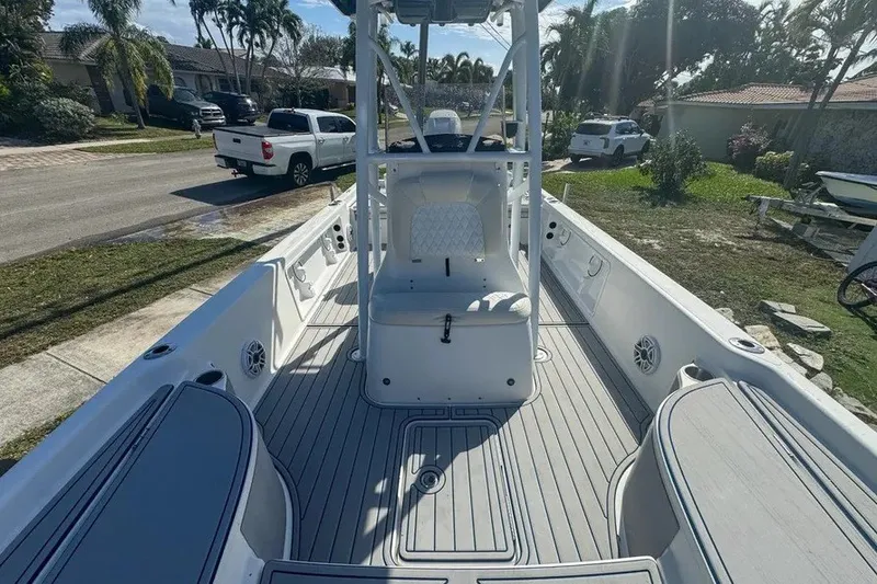 Slide: The Image of 2018 Blue Wave 2400 PureBay boat interior with seating and console, parked in a residential area. - 36