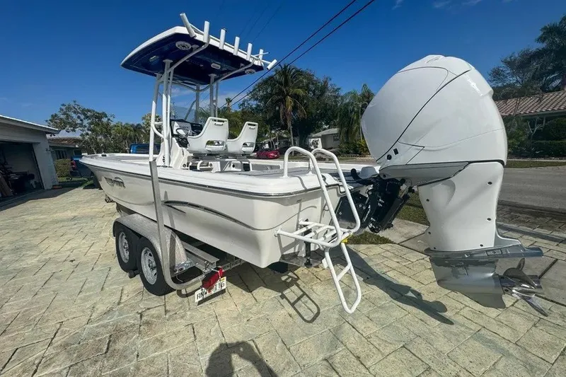 Slide: The Image of 2018 Blue Wave 2400 PureBay boat on trailer, featuring powerful outboard motor. - 5