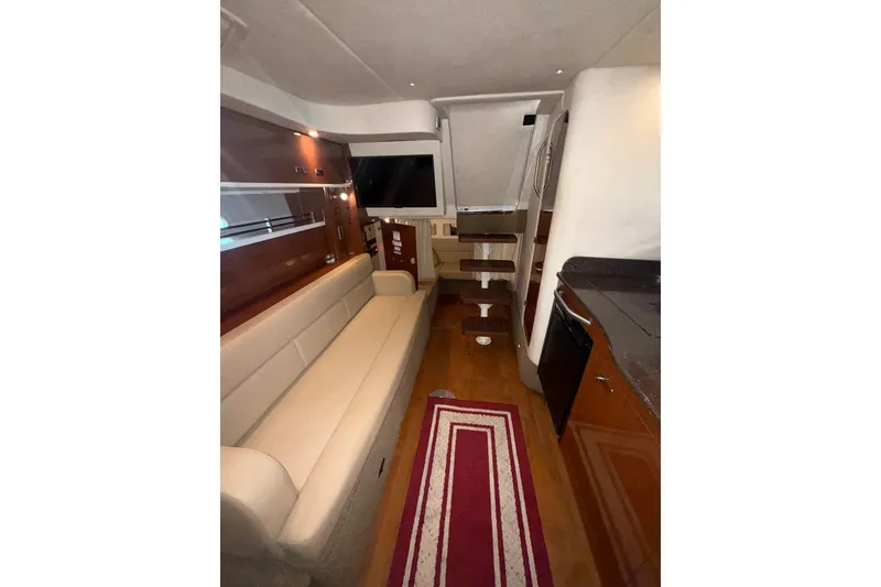 Slide: The Image of Interior of 2012 Sea Ray 335 Sundancer yacht with sofa, TV, and kitchenette. - 14