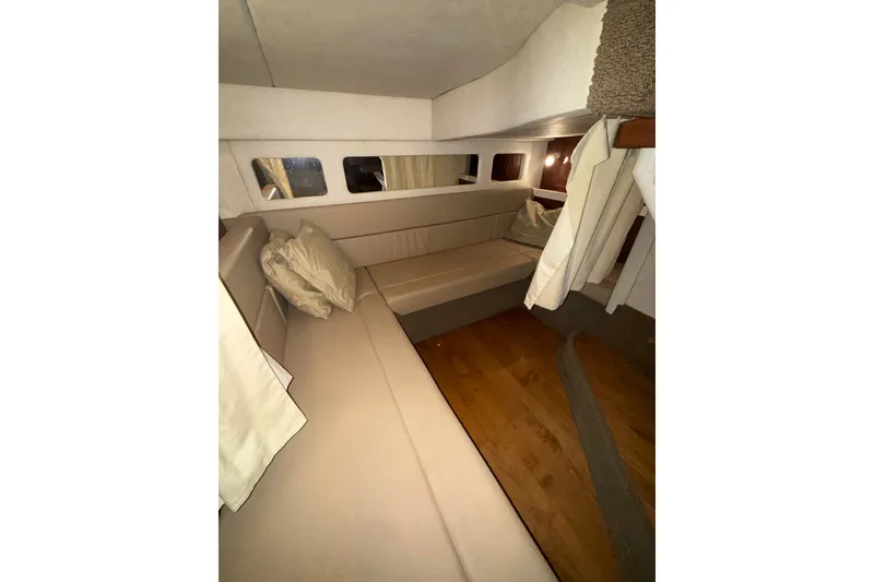 Slide: The Image of Interior cabin of 2012 Sea Ray 335 Sundancer with beige seating and wood flooring. - 13