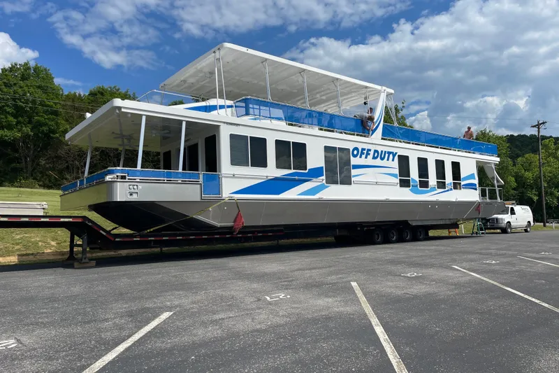 The Image of 2023 Sumerset 18 x 77 LUX houseboat "Off Duty" on trailer in parking lot. - 1