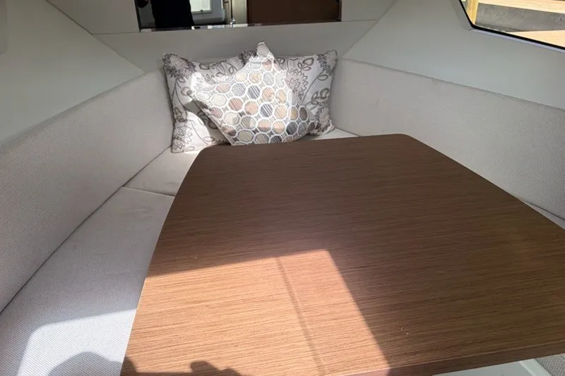 Slide: The Image of Interior cabin of 2019 Jeanneau Leader 9.0 WA with cushions and wooden table. - 11