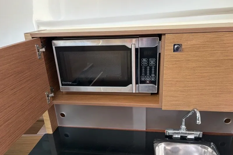 Slide: The Image of Microwave and sink in 2019 Jeanneau Leader 9.0 WA boat kitchen. - 13