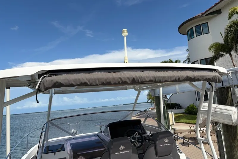 Slide: The Image of 2019 Jeanneau Leader 9.0 WA boat docked by waterfront home, clear sky. - 7