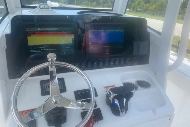 Slide: The Image of 2022 Sea Hunt Gamefish 27CB helm with dual displays and steering wheel. - 15