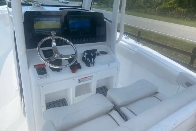 Slide: The Image of 2022 Sea Hunt Gamefish 27CB boat cockpit with steering wheel and navigation displays. - 17