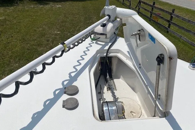 Slide: The Image of 2022 Sea Hunt Gamefish 27CB boat anchor compartment with trolling motor on deck. - 23