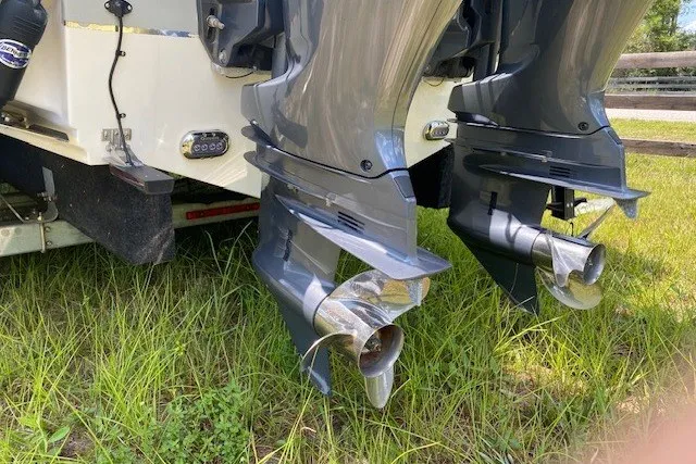 Slide: The Image of 2022 Sea Hunt Gamefish 27CB boat with dual outboard motors on grassy terrain. - 26