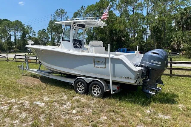 Slide: The Image of 2022 Sea Hunt Gamefish 27CB boat on trailer, parked outdoors. - 27