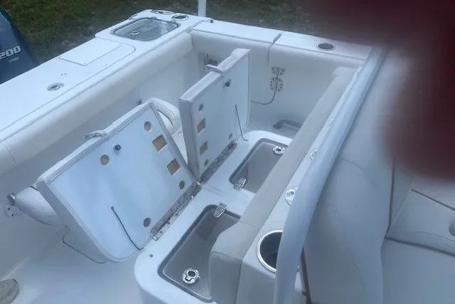 Slide: The Image of 2022 Sea Hunt Gamefish 27CB boat interior with open storage compartments and seating. - 19
