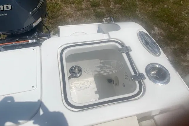 Slide: The Image of 2022 Sea Hunt Gamefish 27CB boat with open storage compartment and Yamaha engine. - 21