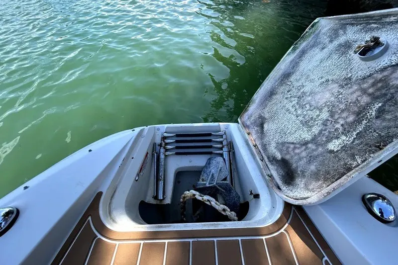 Slide: The Image of 2007 Sea Ray 260 Sundeck boat with open storage compartment near water. - 82