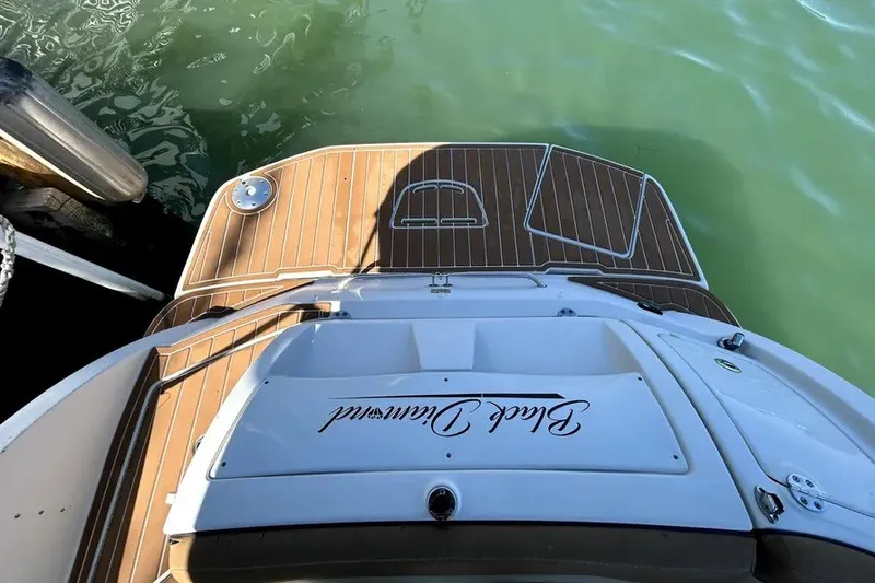Slide: The Image of 2007 Sea Ray 260 Sundeck boat with teak deck, docked on calm water. - 25