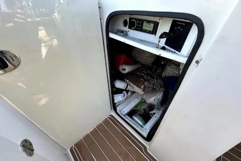 Slide: The Image of Storage compartment on a 2007 Sea Ray 260 Sundeck boat, containing various items. - 71