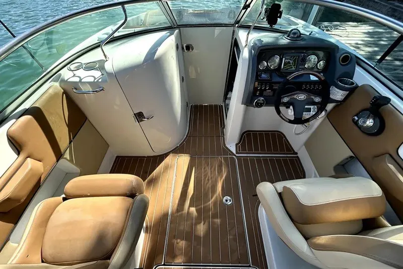 Slide: The Image of 2007 Sea Ray 260 Sundeck interior with helm, seating, and wood flooring. - 17