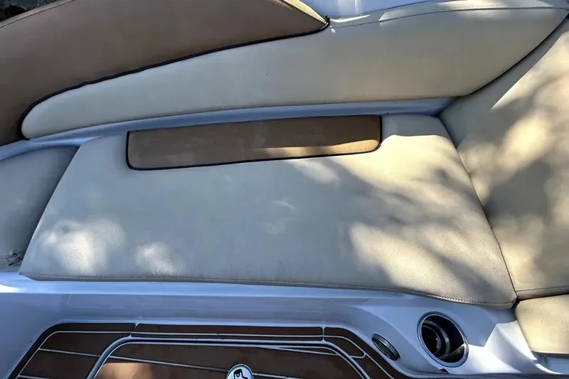 Slide: The Image of 2007 Sea Ray 260 Sundeck boat seating area with beige upholstery and cup holder. - 84