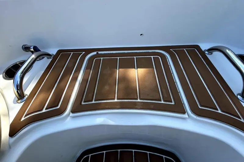Slide: The Image of 2007 Sea Ray 260 Sundeck swim platform with brown non-slip decking and stainless steel handles. - 68