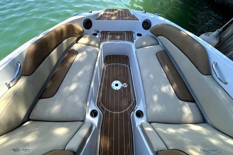 Slide: The Image of 2007 Sea Ray 260 Sundeck interior with cushioned seating and wood accents on a sunny day. - 16