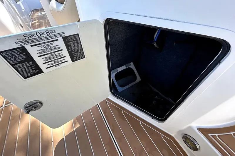 Slide: The Image of Open storage compartment on 2007 Sea Ray 260 Sundeck boat with safety instructions. - 34