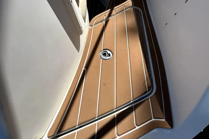Slide: The Image of Deck of 2007 Sea Ray 260 Sundeck boat with brown flooring and metal railing. - 28