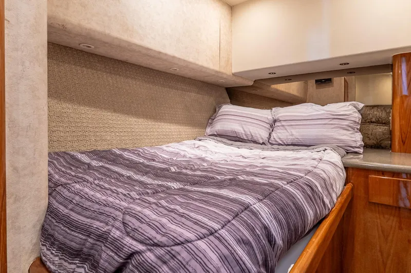 Slide: The Image of Cozy bedroom interior of 2003 Egg Harbor 42 Convertible yacht with striped bedding. - 22