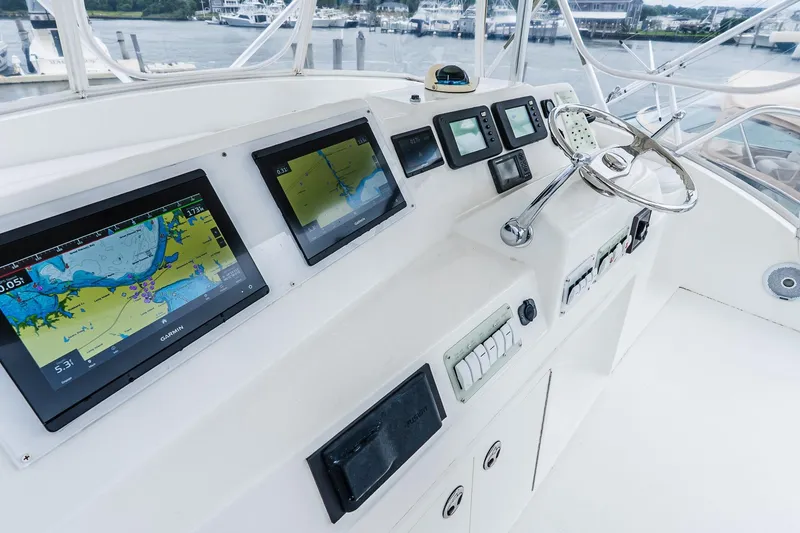 Slide: The Image of Control panel of 2003 Egg Harbor 42 Convertible yacht with navigation screens and steering wheel. - 33