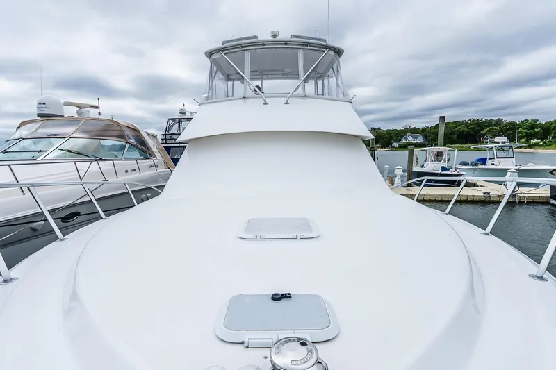 Slide: The Image of 2003 Egg Harbor 42 Convertible yacht docked at marina under cloudy sky. - 23