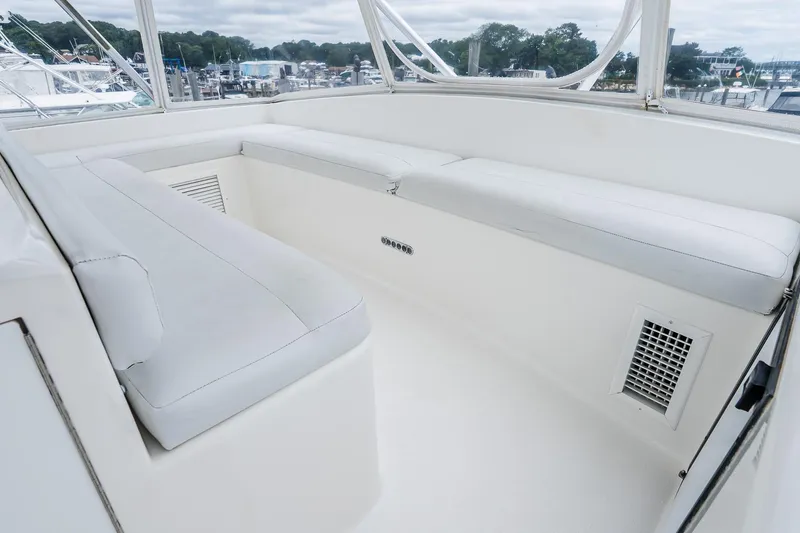 Slide: The Image of 2003 Egg Harbor 42 Convertible yacht interior with white seating and marina view. - 26