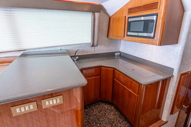 Slide: The Image of 2003 Egg Harbor 42 Convertible yacht kitchen with modern appliances and sleek wooden cabinetry. - 17