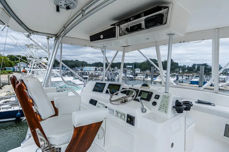 Slide: The Image of 2003 Egg Harbor 42 Convertible yacht helm with modern controls and marina view. - 29