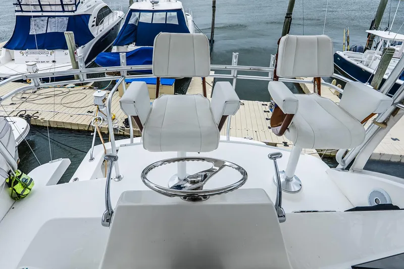Slide: The Image of Flybridge of 2003 Egg Harbor 42 Convertible yacht with white captain chairs and steering wheel. - 28