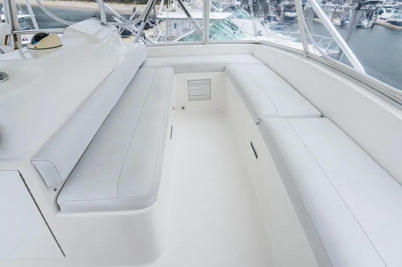 Slide: The Image of Interior seating area of a 2003 Egg Harbor 42 Convertible yacht, featuring white cushioned benches. - 25