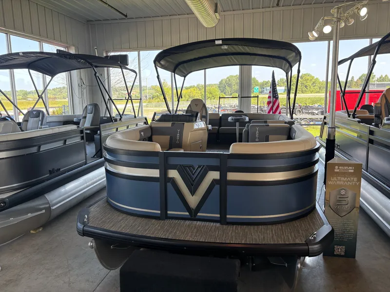 The Image of A 2027 Viaggio X20C pontoon boat is displayed in a showroom. It features a blue exterior and beige seating. - 0