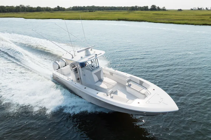 Slide: The Image of 2025 Contender 32 ST boat cruising on a serene waterway. - 6