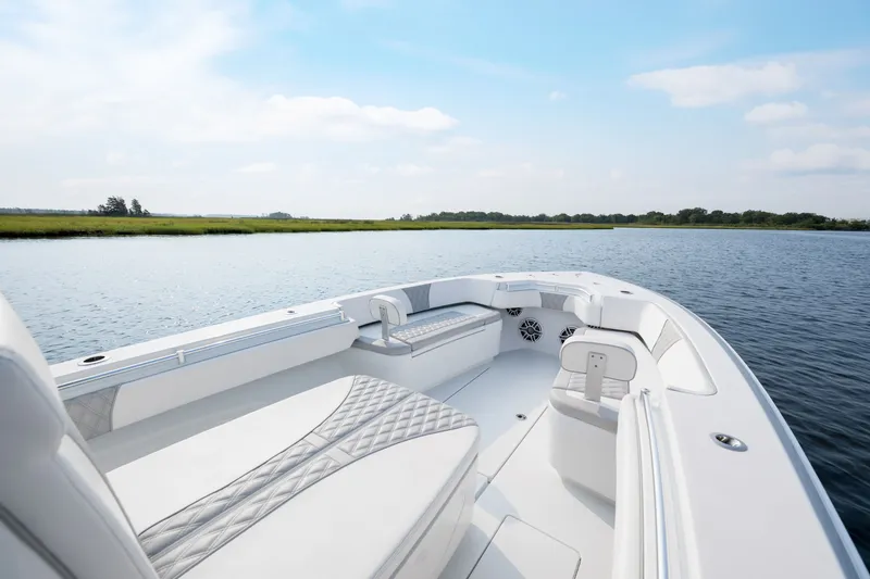 Slide: The Image of 2025 Contender 32 ST boat on calm water, featuring sleek seating and modern design. - 10