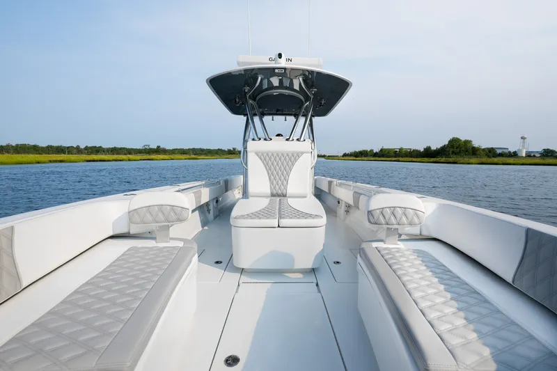 Slide: The Image of 2025 Contender 32 ST boat interior with luxurious seating on a calm waterway. - 13