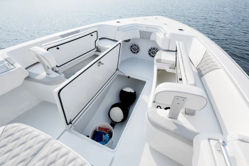 Slide: The Image of 2025 Contender 32 ST boat interior with open storage compartments and seating, on calm water. - 18