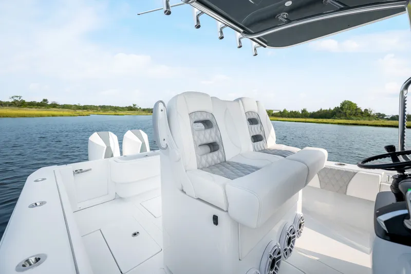 Slide: The Image of 2025 Contender 32 ST boat interior with luxurious seating on a serene water backdrop. - 26