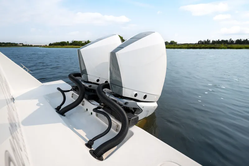 Slide: The Image of 2025 Contender 32 ST boat with dual outboard engines on a calm waterway. - 35