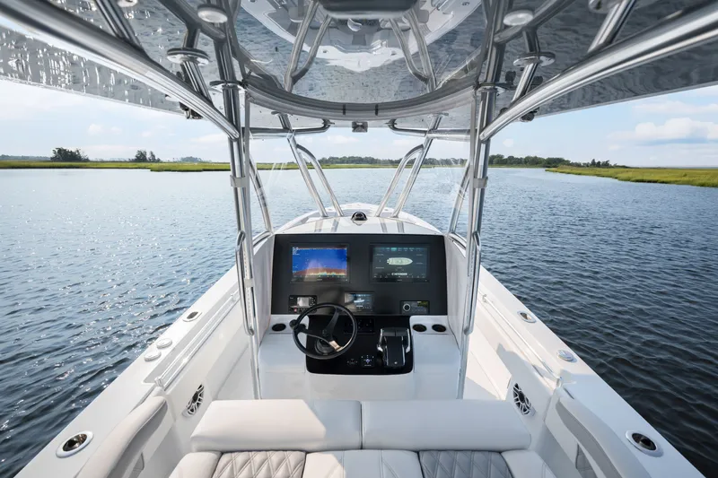Slide: The Image of 2025 Contender 32 ST boat interior with advanced navigation system on a serene waterway. - 22