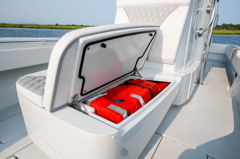 Slide: The Image of 2025 Contender 32 ST boat with open storage compartment holding life jackets. - 20