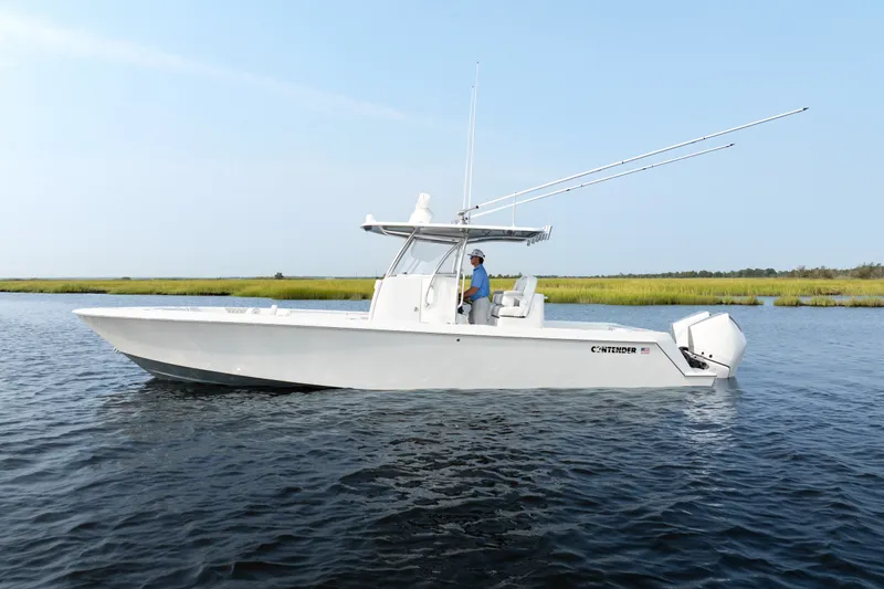 Slide: The Image of 2025 Contender 32 ST boat on calm water, side view with fishing rods. - 1