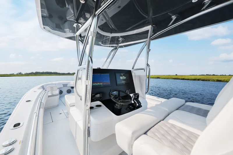 Slide: The Image of 2025 Contender 32 ST boat interior with modern helm, on calm water. - 23