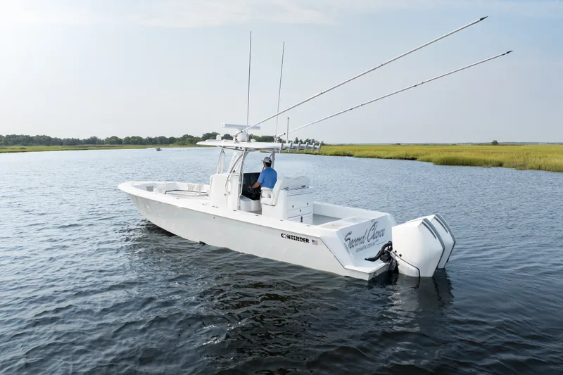 Slide: The Image of 2025 Contender 32 ST boat cruising on calm waters, featuring dual outboard engines. - 3