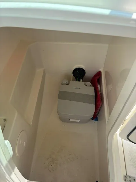 Slide: The Image of A compact toilet area with a portable toilet and a red flotation device. - 6
