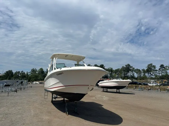 Slide: The Image of A 2025 Boston Whaler 240 Vantage is on a dry dock under a cloudy sky. - 2