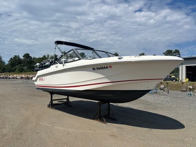 Slide: The Image of A 2025 Boston Whaler 210 Vantage is on a dry dock under a cloudy sky. - 1