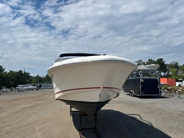 Slide: The Image of A 2025 Boston Whaler 210 Vantage is on a dry dock under a cloudy sky. - 4